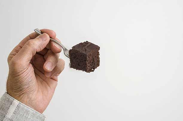man eating chocolate cake stock photo