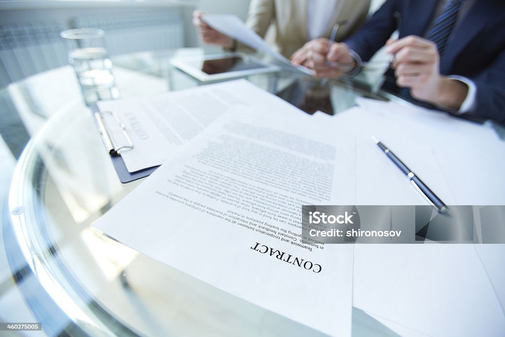 Workplace with papers Business documents and pen at workplace with working people on background Asking Stock Photo