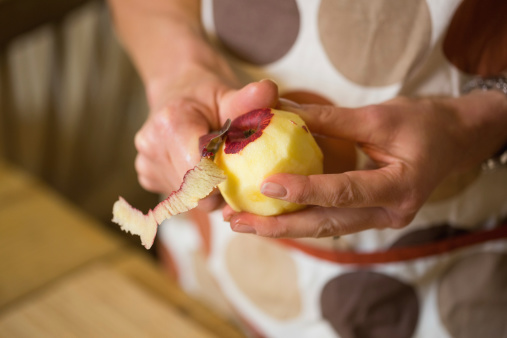 Close up of a woman preparing apple in a kitchen