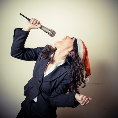 christmas businesswoman singing with microphone on white background