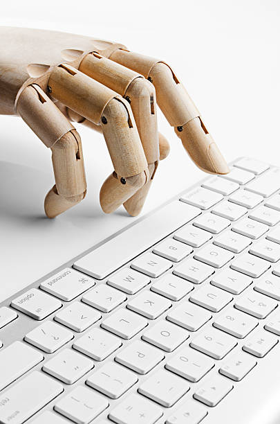 Artificial hand using a computer keyboard stock photo