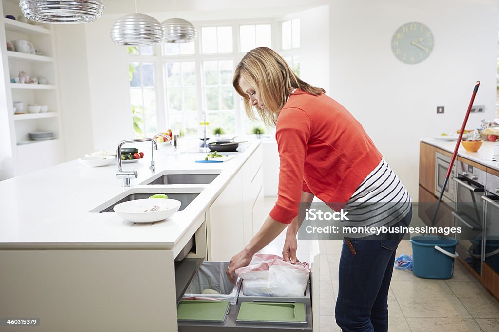 Woman Standing In Kitchen Emptying Waste Bin Woman Standing In Kitchen Full Up Emptying Waste Bin Kitchen Stock Photo