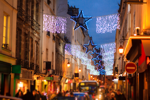 Christmas garland over illuminated crowded street in Paris, France