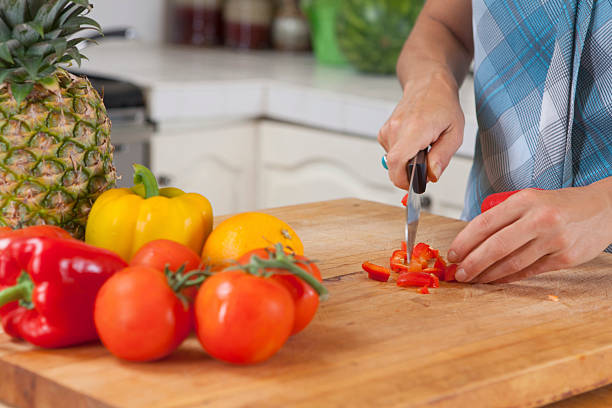 Mujer picar orgánicos pimientos primer plano - foto de stock