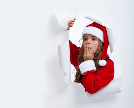 Surprised Santa girl looking through hole in paper - with copy space