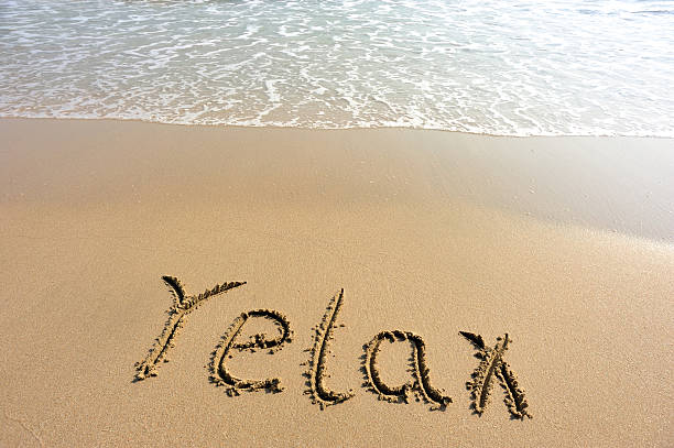 istock word relax drawn on the sand 460355895