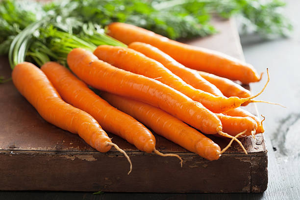 istock fresh carrot over wooden background 460356087