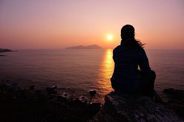 istock woman hiker sit on rock face the sunrise 460357767