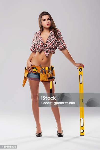 Sexy Woman Leaning On Yellow Spirit Level Stock Photo - Download Image Now - Construction Industry, Leaning, Building Contractor