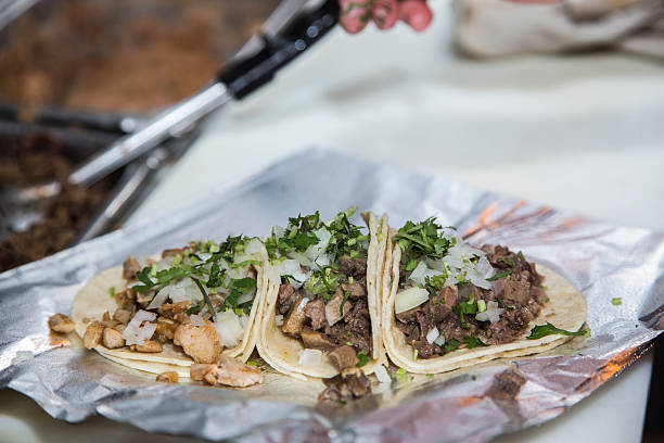 istock Three freshly prepared tacos on foil 460387885