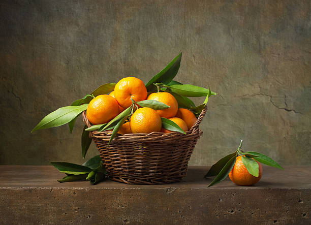 naturaleza muerta con tangerines en una cesta - naturaleza muerta fotografías e imágenes de stock