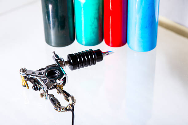 Tattoo gun with ink tubes on white background stock photo