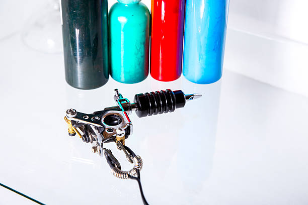 Tattoo gun with ink tubes on white background stock photo