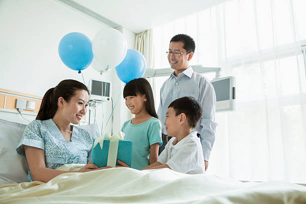 pai e filhos visitar a sua mãe no hospital - men giving balloon women - fotografias e filmes do acervo