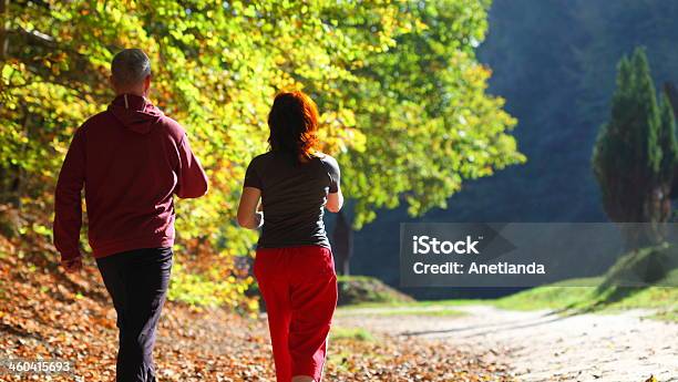 Woman And Man Walking Cross Country Trail In Autumn Forest Stock Photo - Download Image Now