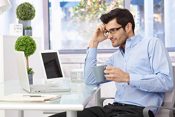 istock Young man sitting at desk working 460417753