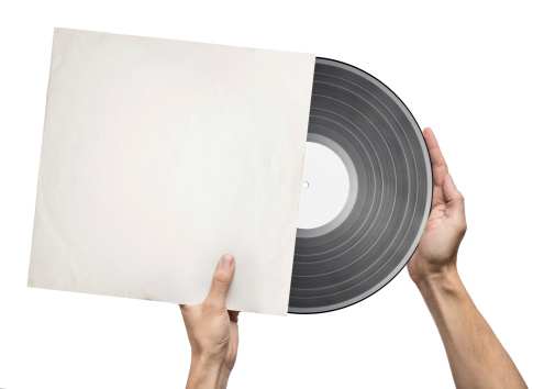 Hands holding vinyl record in a paper case
