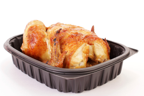 Roast Chicken Dinner cooked and packaged by grocery story and brought home ready to serve.  Still in plastic contain against white background.  Chicken To Go.