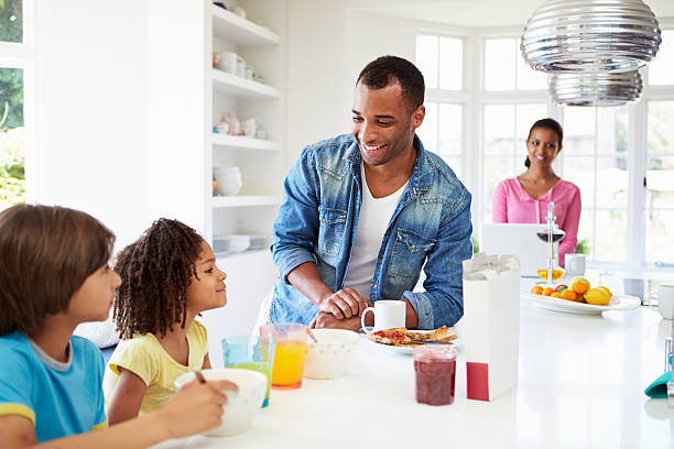 istock Mother, father and children having breakfast in kitchen 460422993