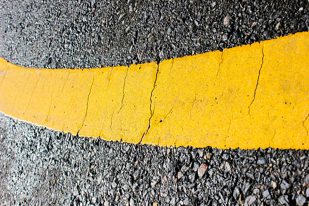 istock asphalt road yellow line close up background 460423215