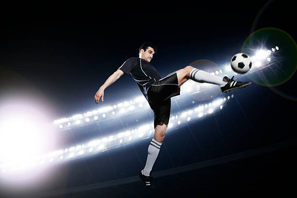 istock Soccer player in mid-air kicking the ball 460423597