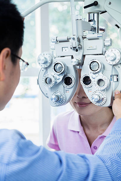 istock Optometrist doing an eye exam on young woman 460423625
