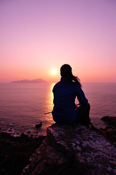 istock woman hiker sit on rock face the sunrise 460424237