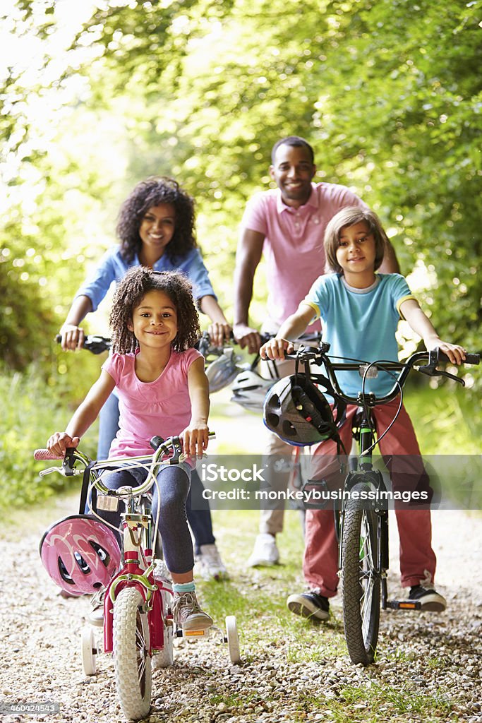 African American Family On Cycle Ride In Countryside African American Family On Cycle Ride In Countryside Smiling At Camera Family Stock Photo