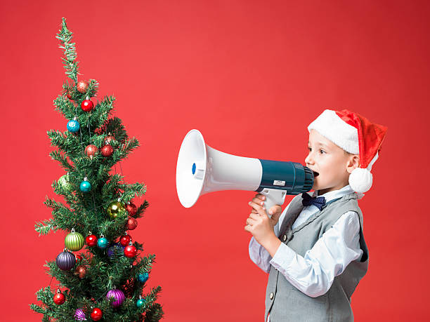 istock Little boy with santa hat Shouting With Megaphone 460425199