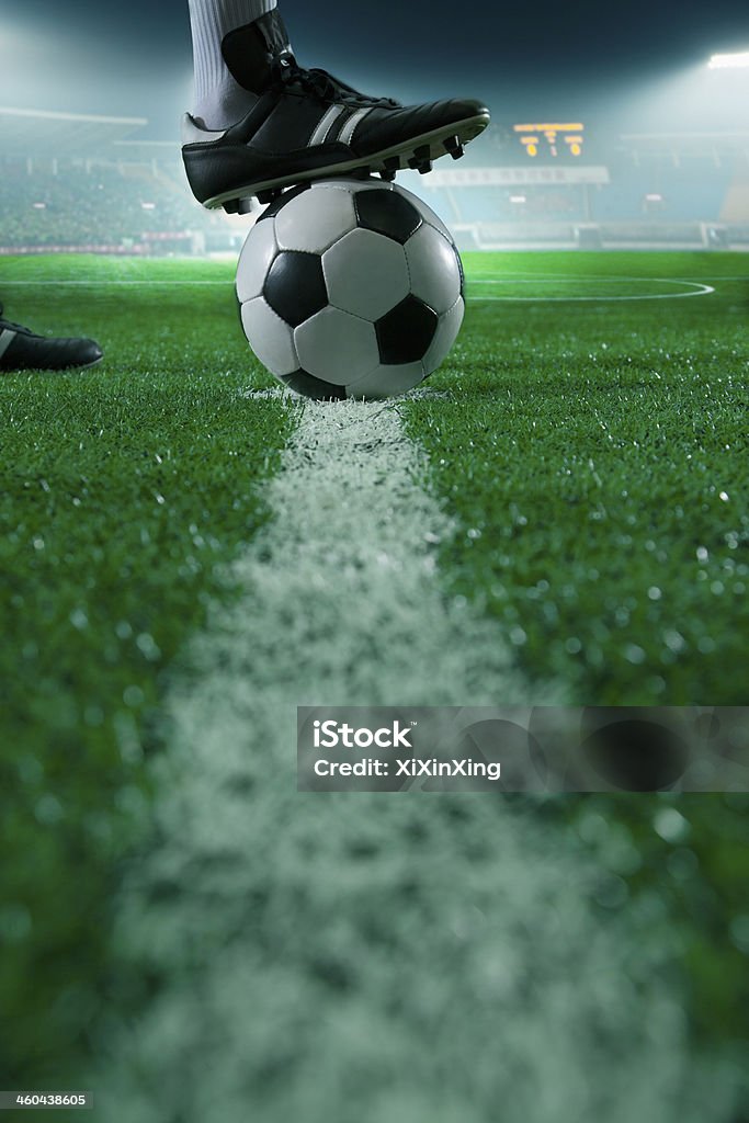 Foot on top of soccer ball Close up of foot on top of soccer ball on the line, side view, stadium Soccer Stock Photo