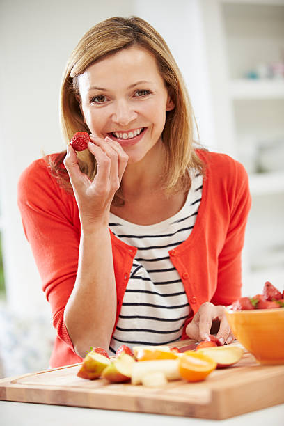 istock Woman Preparing Fruit Salad In Kitchen 460442433