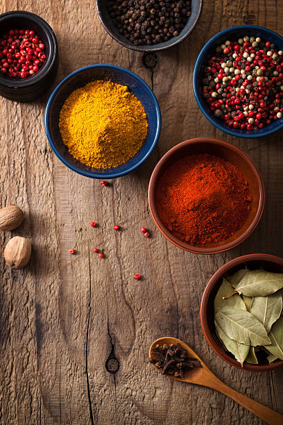 istock spices in bowls: pink and black pepper, paprika powder, curry 460445831