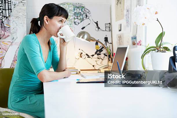 Businesswoman Drinking Coffee At Office Desk Stock Photo - Download Image Now - Adult, Artist, Business