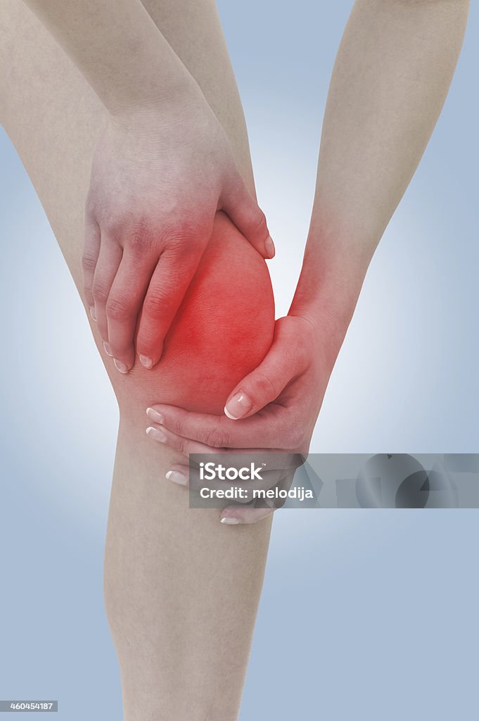 Acute pain in a woman  knee. Acute pain in a woman  knee. Female holding hand to spot of knee-aches. Concept photo with Color Enhanced blue skin with read spot indicating location of the pain. Adult Stock Photo