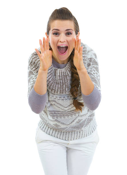 istock Young woman in sweater shouting through megaphone shaped hands 460464315