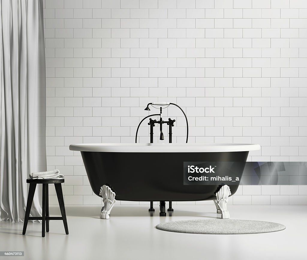 Black and white classic bathtub on brick wall Black and white classic bathtub with stool and rug Bathtub Stock Photo