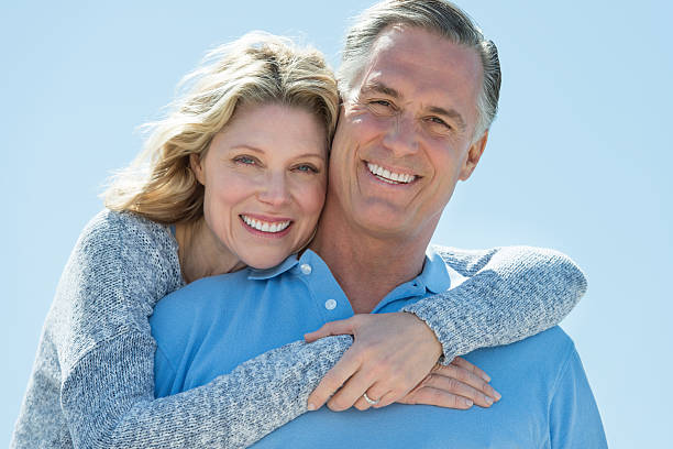 istock Woman embracing man from behind under clear sky 460476115