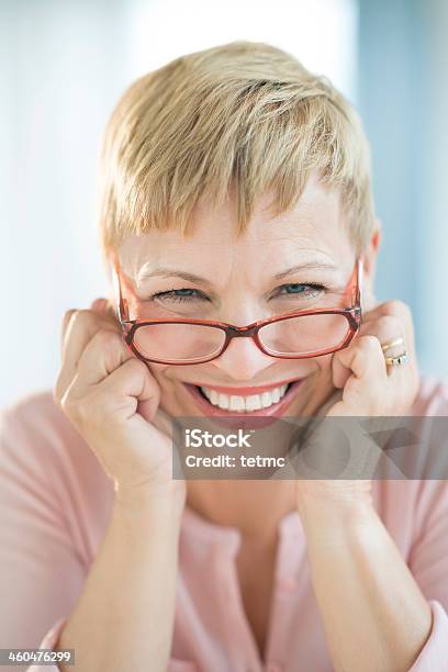 Smiling Woman With Red Glasses Positioned On Nose Bridge Stock Photo - Download Image Now