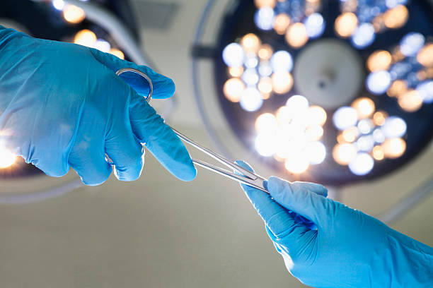 Close-up of gloved hands passing the surgical scissors stock photo