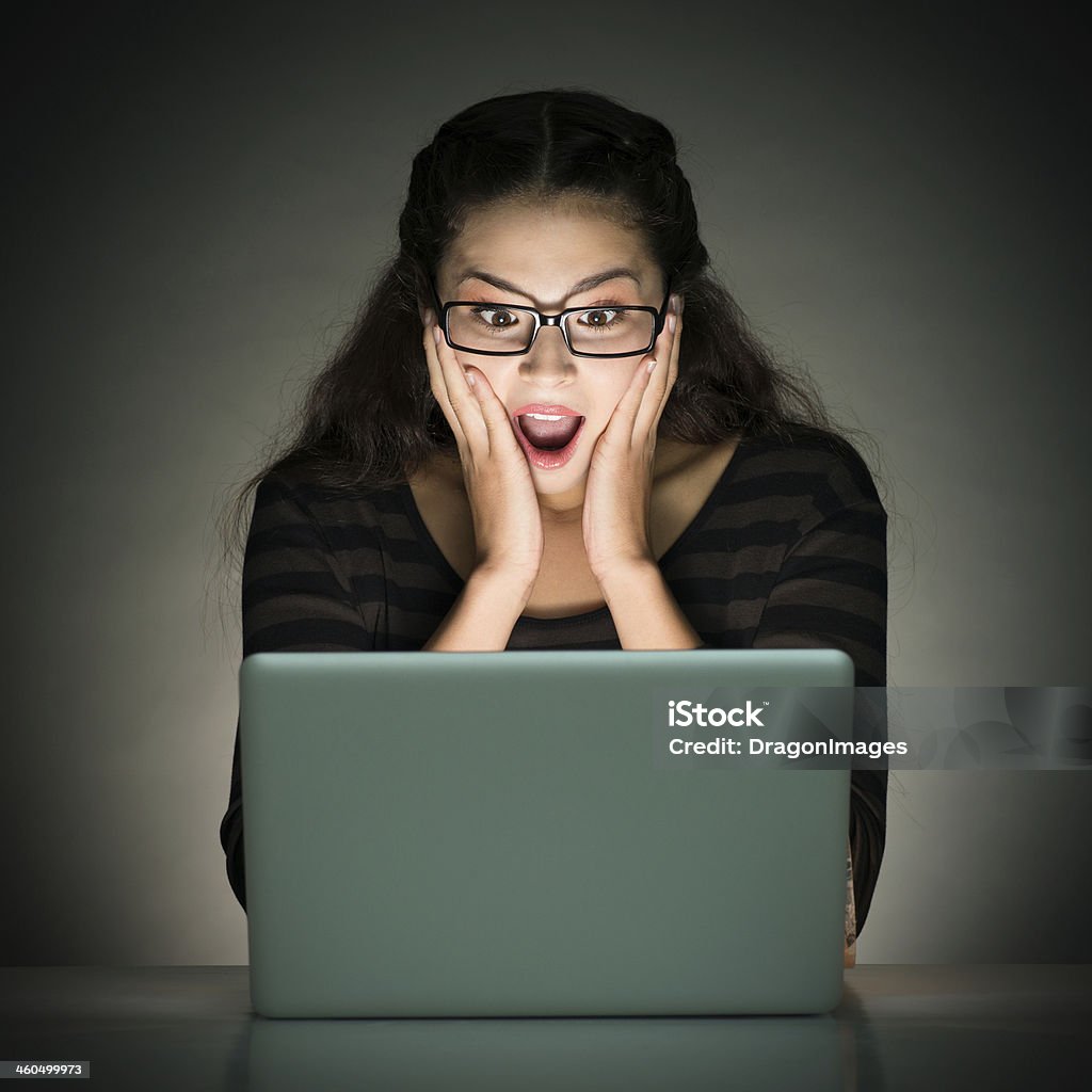 Shocked of information Image of a young girl shocked of information while networking over grey Adult Stock Photo