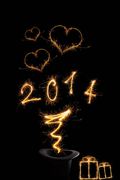 Magical new year 2014. Magical new year. Magical fireworks from black top hat forming 2014 and abstract light lines isolated on black background. Happy new year background. 2014 stock pictures, royalty-free photos & images