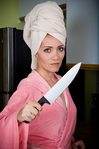Angry woman holding a knife at the camera.