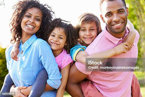 African American Parents Giving Children Piggyback Rides Stock Photo - Download Image Now