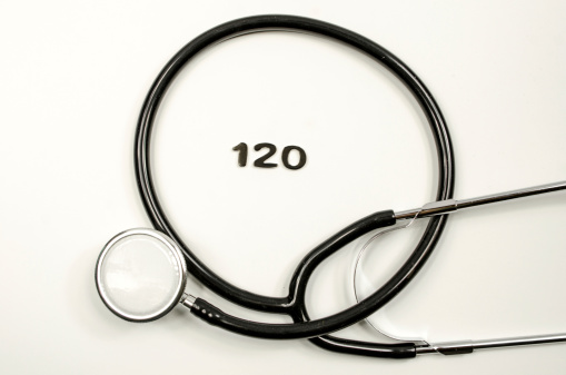 A black stethoscope isolated on a light background showing the numbers for a blood pressure reading of 120.