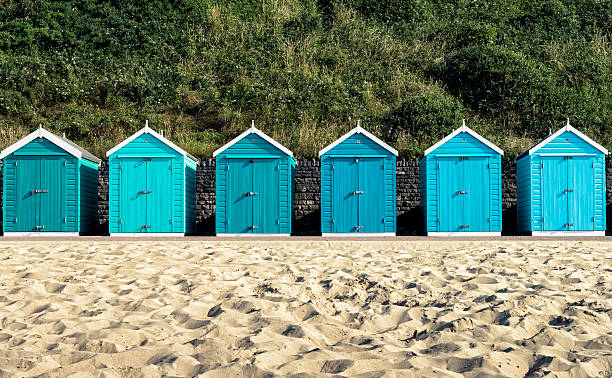 Turquoise painted wooden beach huts in Bournemouth Beach huts at Bournemouth, Dorset, UK. beach hut stock pictures, royalty-free photos & images