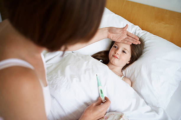 istock Mother checking temperature of sick child in bed 460545577