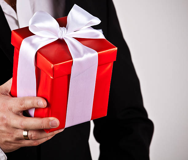 istock close up of man hands holding gift box 460549107