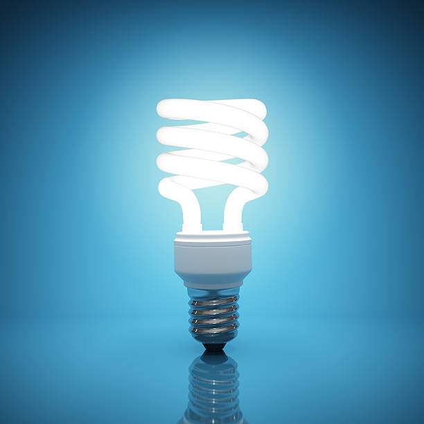Bright, illuminated light bulb on blue background Illuminated light bulb on blue background energy efficient lightbulb stock pictures, royalty-free photos & images