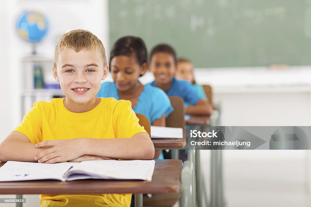 elementary schoolboy with classmates cute elementary schoolboy with classmates in classroom Classroom Stock Photo