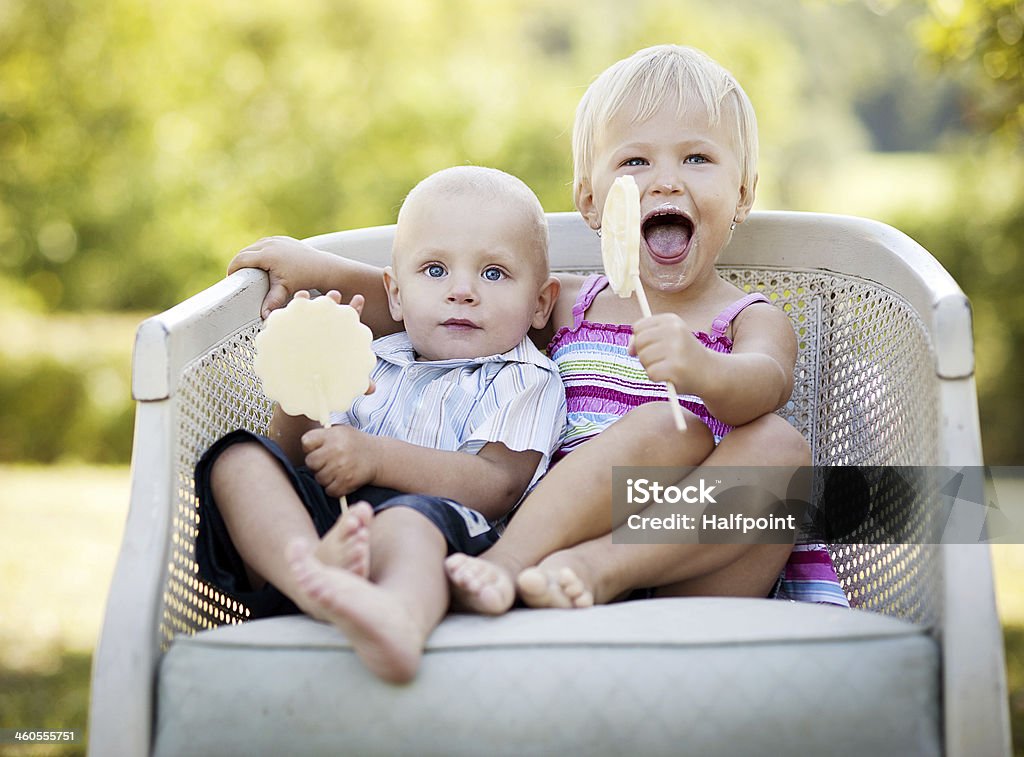 Happy kids Two happy kids eating lolly in the park Blond Hair Stock Photo